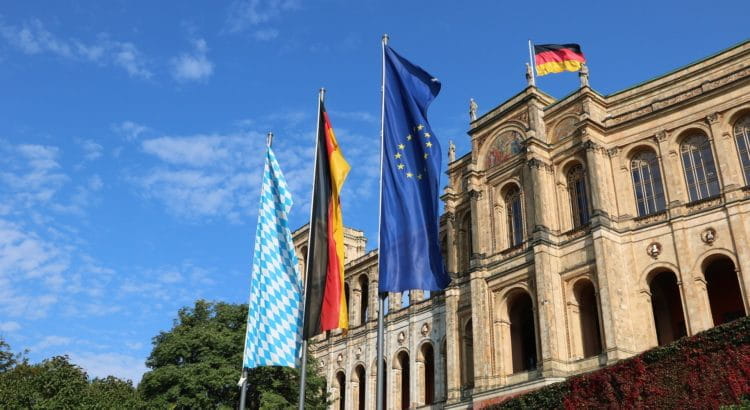 Maximilianeum in Bayern; davor drei Flaggen: Europa, Deutschland, Bayern.