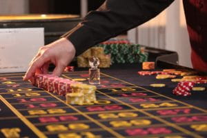 Croupier platziert Einsätze am Roulette-Tisch.