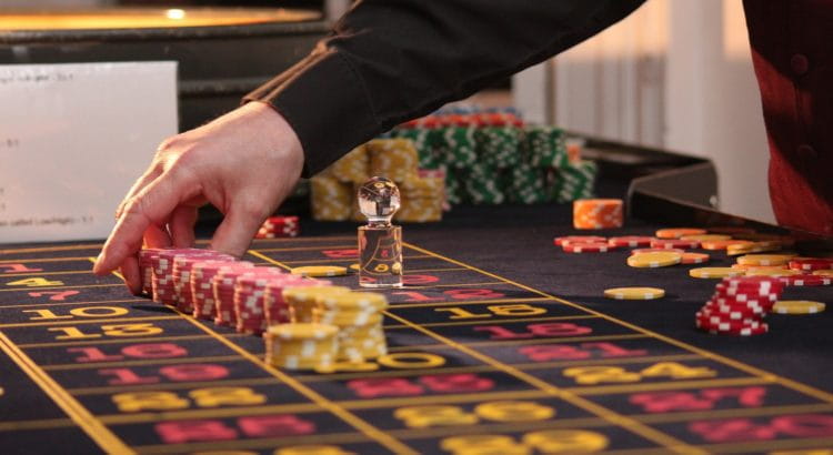 Croupier platziert Einsätze am Roulette-Tisch.