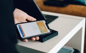 Eine Hand hält ein Smartphone mit einer virtuellen Kreditkarte.