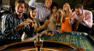 Eine Gruppe feiernder Spieler steht vor einem Roulette Kessel.