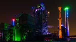 Industriebetrieb in der Stadt Duisburg bunt angeleuchtet bei nächtlicher Dunkelheit.