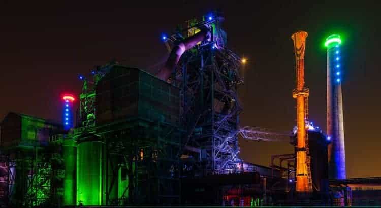 Industriebetrieb in der Stadt Duisburg bunt angeleuchtet bei nächtlicher Dunkelheit.