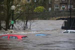 In einer Kleinstadt steht das Wasser so hoch, dass selbst Autos bis zum Dach unter den Flutwellen verschwunden sind.