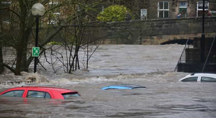 In einer Kleinstadt steht das Wasser so hoch, dass selbst Autos bis zum Dach unter den Flutwellen verschwunden sind.