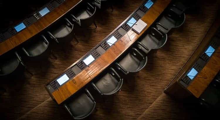 Zahlreiche leere identische Sitze in einem deutschen Landtag.