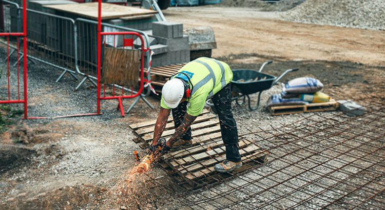 Ein Bauarbeiter arbeitet am Tag auf einer Baustelle.