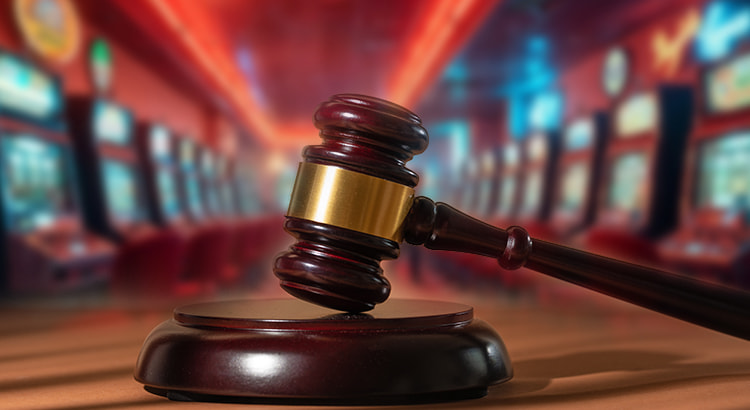 Eine Spielhalle mit einem Slot-Automaten im Vordergrund, vor dem ein offenes Gesetzbuch und ein Richterhammer liegen. Im Hintergrund sind verschwommene weitere Slot-Automaten und ein Mitarbeiter zu sehen, der das Geschehen überwacht