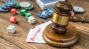 Ein moderner Sitzungssaal im österreichischen Parlament, in dem legislative Diskussionen stattfinden. Auf einem Holztisch liegen gestapelte Dokumente, darunter ein Entwurf für ein Bundesgesetz, Brillen und ein Stift. Im Hintergrund sind fünf Personen in formeller Kleidung in eine Unterhaltung vertieft, während die österreichische und die EU-Flagge sichtbar sind