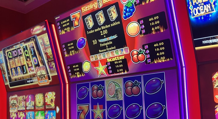 Neue Novoline-Geräte mit Sizzling Book und Fruchtsymbolen im rot beleuchteten Automatensaal der Spielbank Kassel