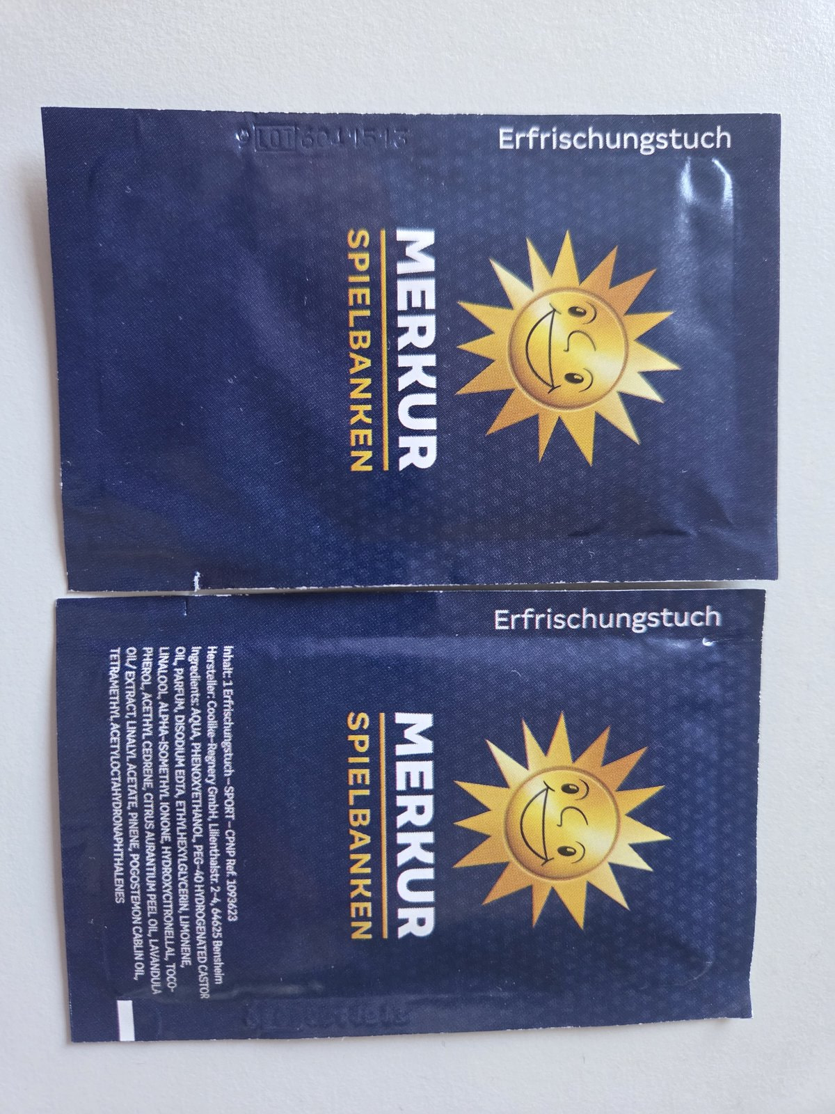 Zwei Erfrischungstücher mit Merkur-Logo, die am Eingang ausliegen