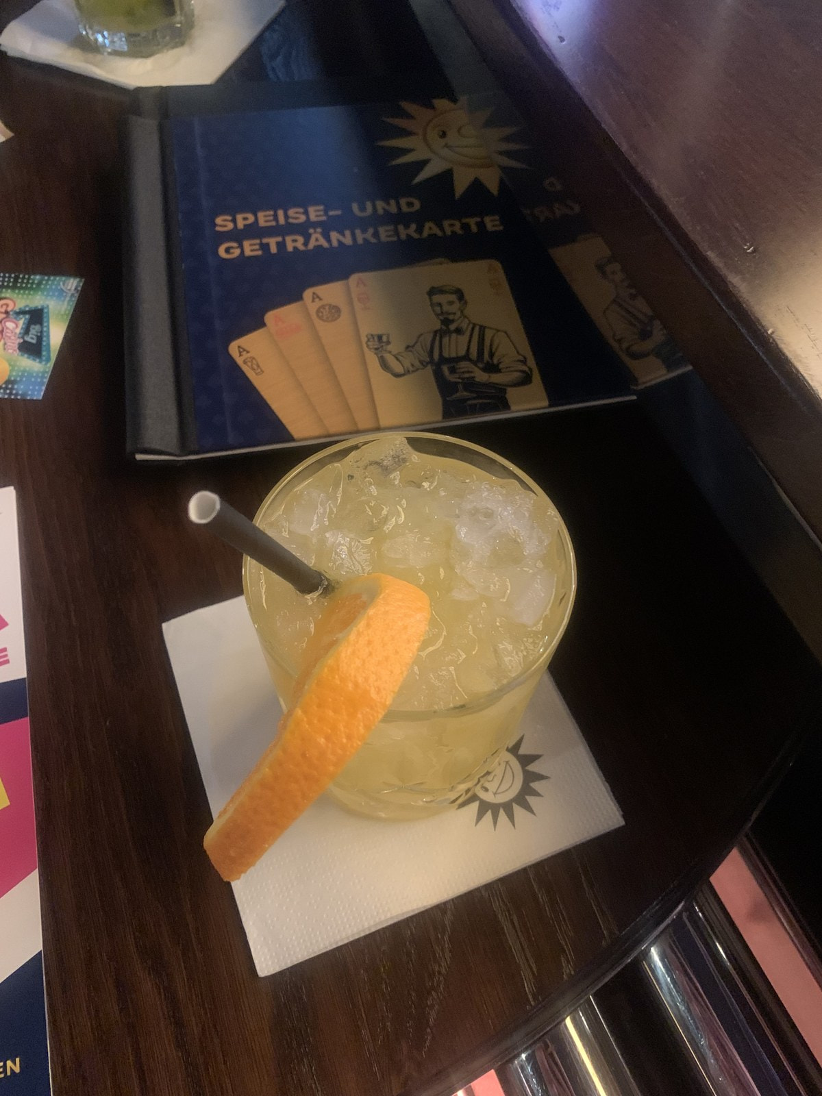 Cocktail mit Orangenschale vor der Speise- und Getränkekarte an der Bar der Spielbank Bad Oeynhausen