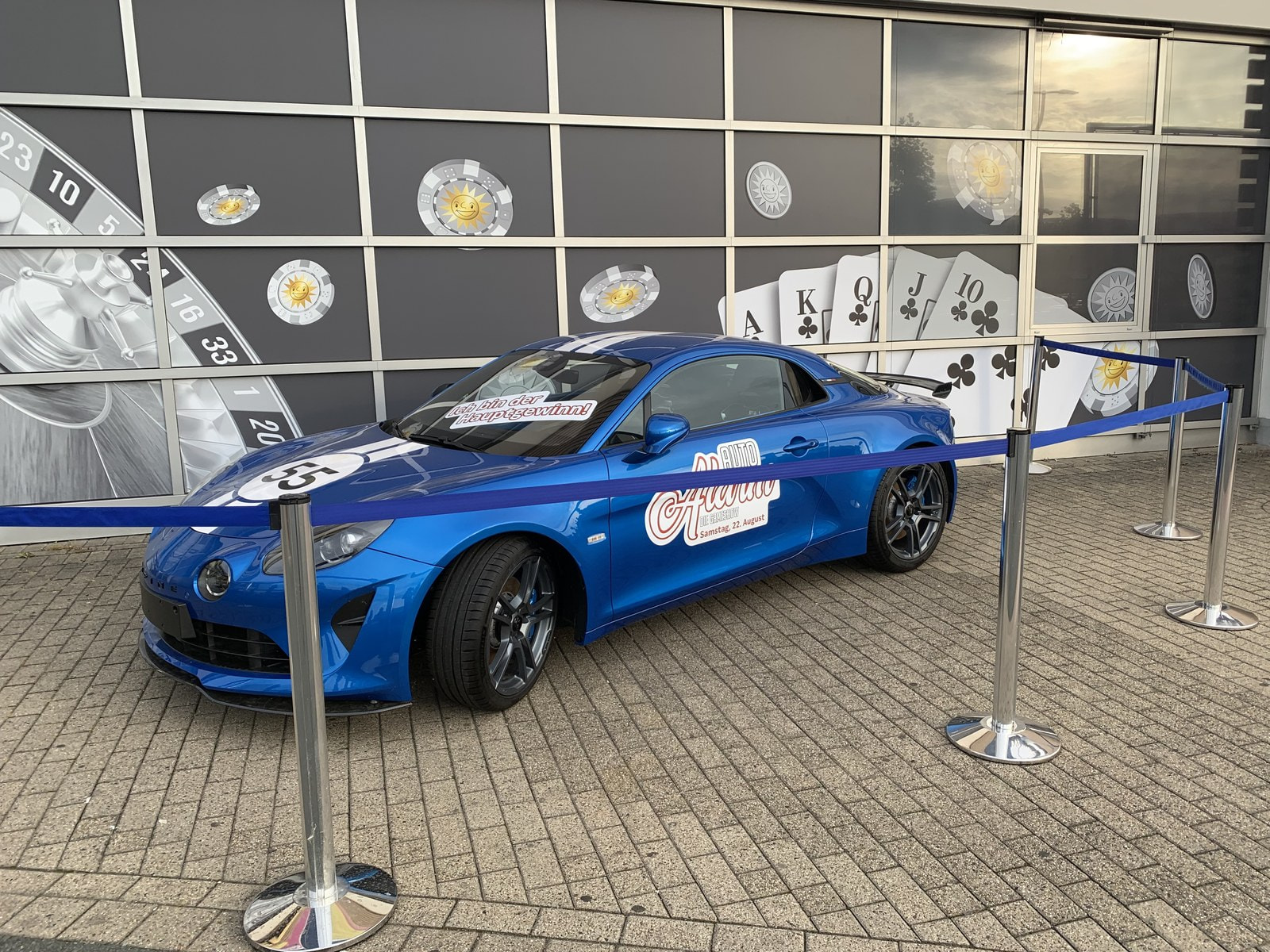 Blauer Sportwagen als Gewinnspielpreis vor der Fassade der Spielbank Bad Oeynhausen