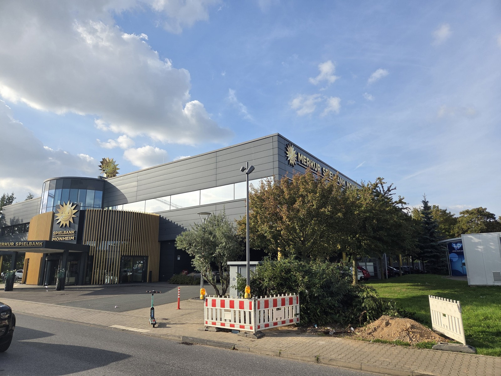 Gebäude der Merkur Spielbank Monheim mit goldener Sonne und Eingang