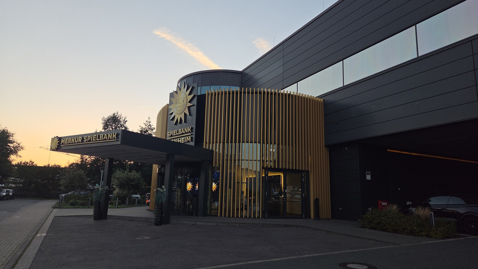 Eingang der Merkur Spielbank Monheim in der Abenddämmerung